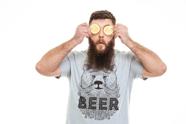 Homme barbu drôle yeux couverts avec deux tranches de citron — Photo