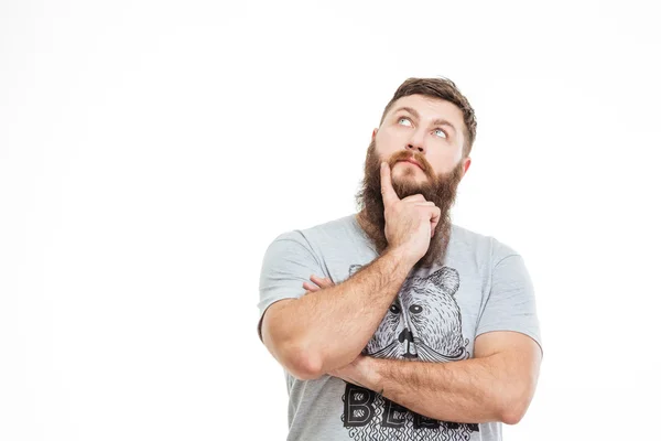 Задумчивый привлекательный бородатый мужчина смотрит вверх и думает: — стоковое фото