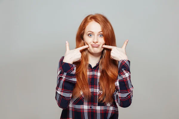 Kvinnan pekar finger mot hennes kind — Stockfoto