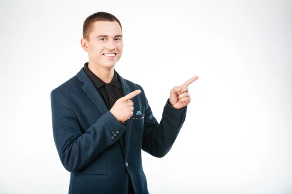 Smiling businessman pointing finger away — Stock Photo, Image