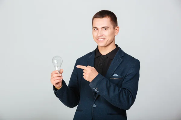 Happy businessman holding bulb — Stock Photo, Image