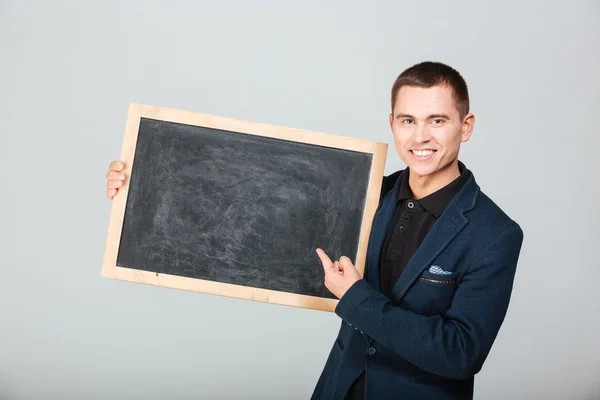 Smiling businessman holding blank board — Stock Photo, Image