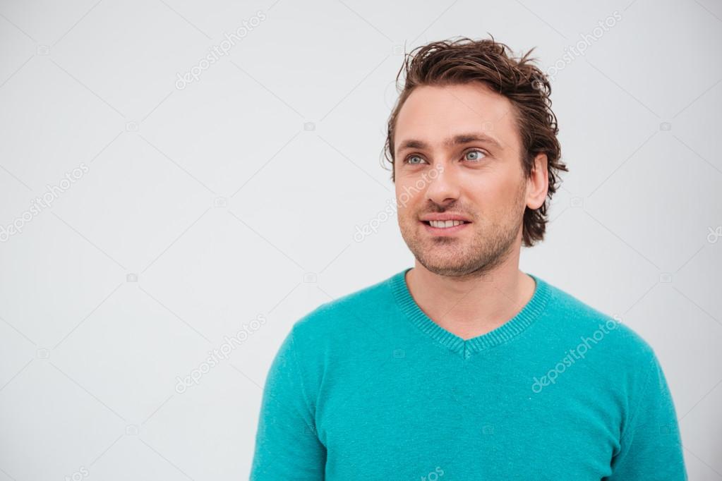Happy attractive man in blue jumper looking up and smiling 