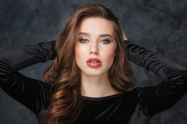 Ellerini başının arkasında olan baştan çıkarıcı kadın