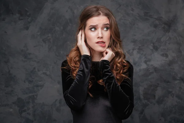 Scared confused young woman biting her lip — Stock Photo, Image
