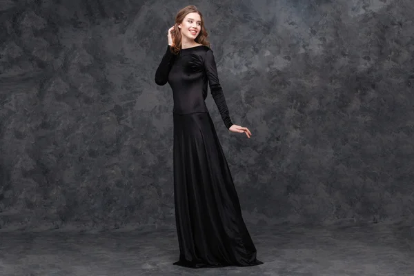 Retrato de encantadora jovem mulher em vestido preto longo — Fotografia de Stock