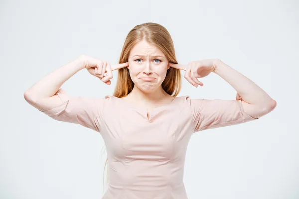 Traurige Frau, die ihre Ohren bedeckt — Stockfoto