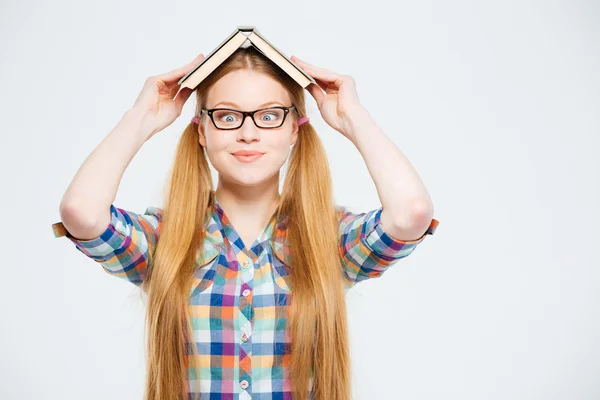 Étudiante drôle avec livre sur la tête — Photo