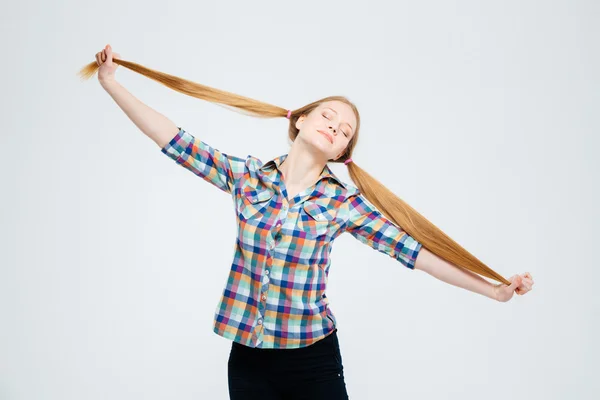 Kvinnelig tenåring med lukkede øyne som holder hestehalene – stockfoto