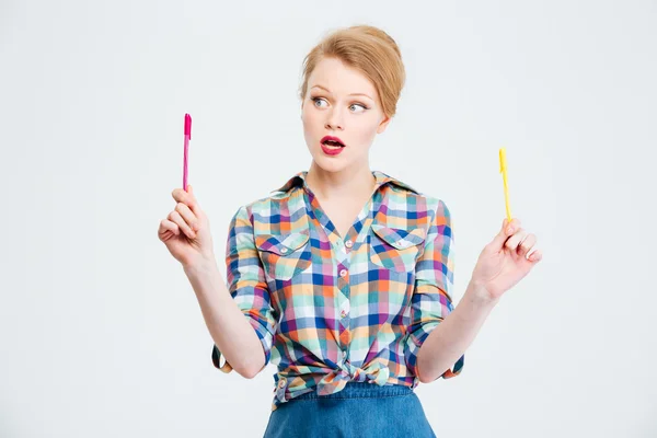 Kvinnan att välja mellan gul och röd penna — Stockfoto
