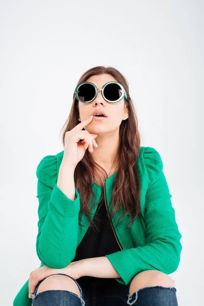 Mujer sorprendida en gafas de sol redondas sentada y mirando hacia arriba —  Fotos de Stock