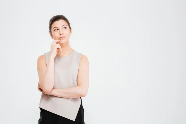 Thoughtful pretty young business woman standing and touching her chin — Stock Photo, Image