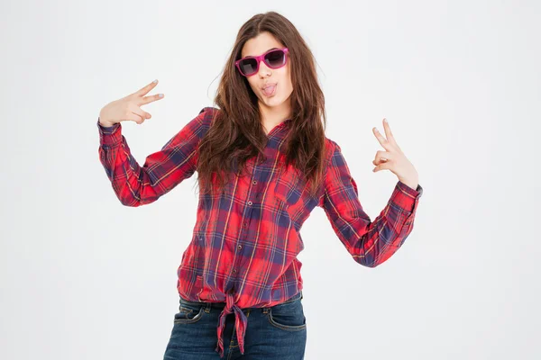 Drôle mignon jeune femme dans rose lunettes de soleil montrant la langue — Photo