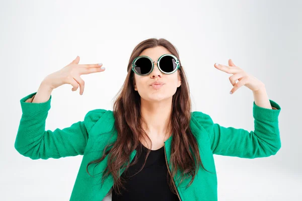 Juguetona joven bonita en gafas de sol redondas apuntando a sí misma — Foto de Stock