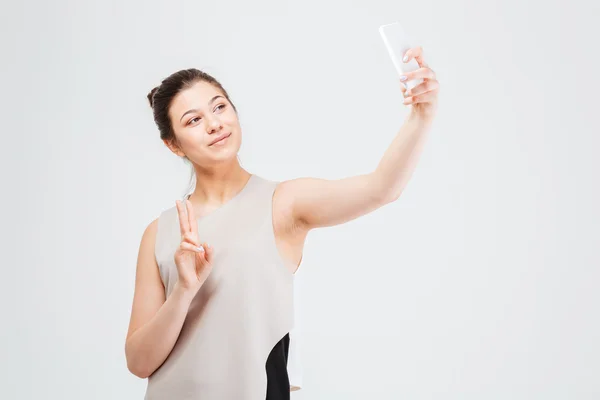 Geschäftsfrau macht Selfie mit Smartphone und zeigt Friedensgeste — Stockfoto