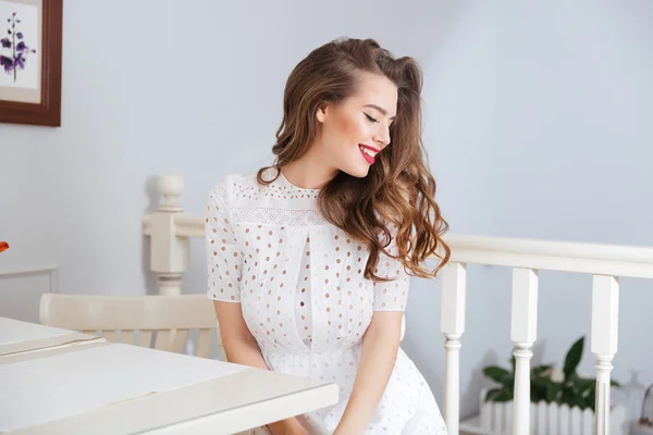 Szczęśliwy piękne Młoda kobieta w białej sukni siedząc w kawiarni — Zdjęcie stockowe
