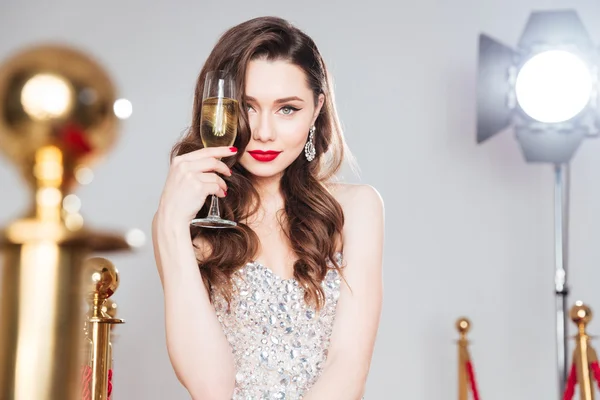 Mulher famosa segurando copo de champanhe — Fotografia de Stock