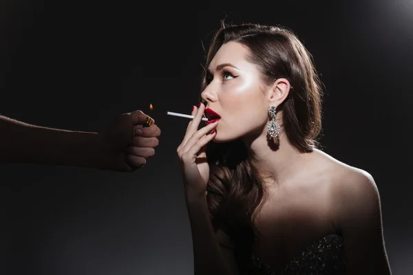 Женщина закуривает сигарету — стоковое фото
