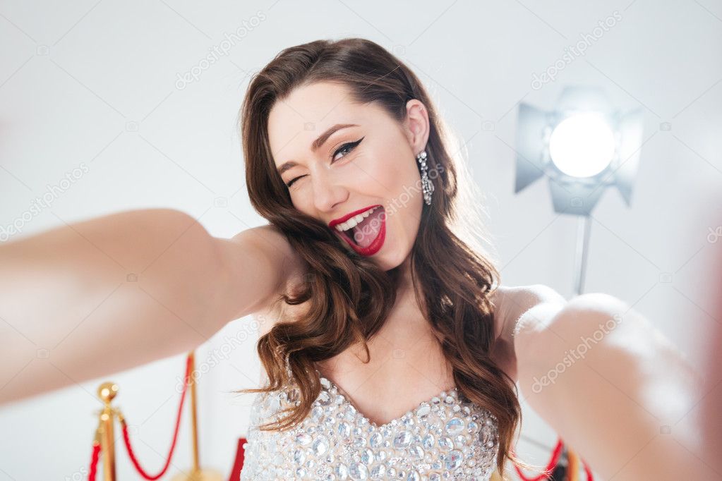 Woman on red carpet making selfie photo 