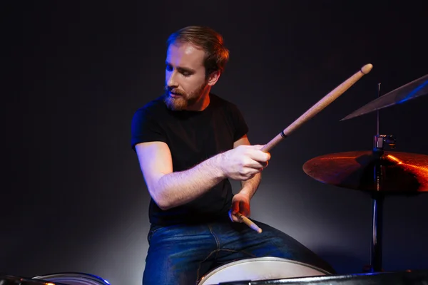 Vousatý muž bubeník se zavřenýma očima, sedí a hraje na bicí nástroje — Stock fotografie