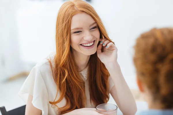 Veselá žena sedí a směje se svým přítelem v kavárně — Stock fotografie