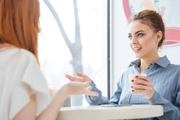 Deux femmes heureuses qui parlent au café — Photo