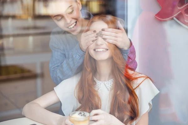 Glückliche Frau verschloss ihre Augen vor ihrer Freundin im Café — Stockfoto