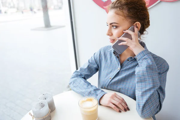 Kahve içme ve cep telefonu kafede konuşurken kadın — Stok fotoğraf