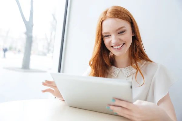 Gladlynt kvinna ler och använda Tablet PC i café — Stockfoto
