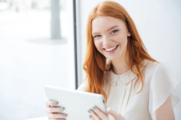 Lycklig kvinnan skrattar och använda Tablet PC i café — Stockfoto