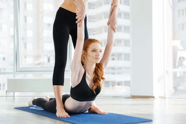 Giovane donna che fa esercizi di stretching con personal trainer — Foto Stock