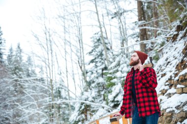Kış orman balta konumu olan Kareli gömlekli adam