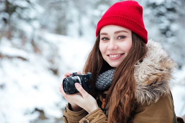 Feliz hermosa mujer fotógrafa tomando fotos en el bosque de invierno — Foto de Stock