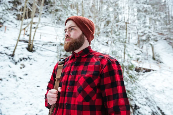 Schwerbärtiger Mann mit Rucksack im winterlichen Bergwald — Stockfoto