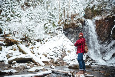 Dalgın sakallı adam stading yakınındaki dağlarda kış, şelale