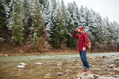 Taşın içinde nehir üzerinde duran erkek uzun yürüyüşe çıkan kimse
