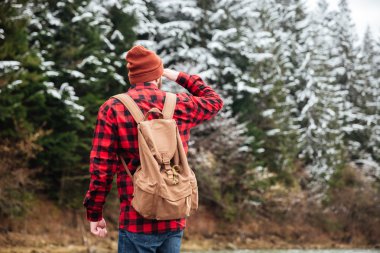 Taşın içinde nehir üzerinde duran erkek uzun yürüyüşe çıkan kimse