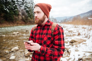 Düşünceli erkek uzun yürüyüşe çıkan kimse holding smartphone