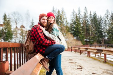 Ormandaki eski köprünün üzerinde oturan Çift