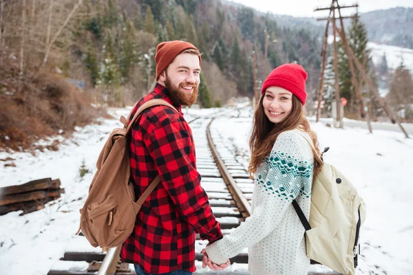 Усміхнена пара, що йде по залізниці — стокове фото