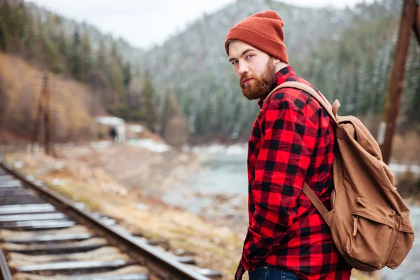 Pohledný vousatý muž na železniční trati v horách — Stock fotografie