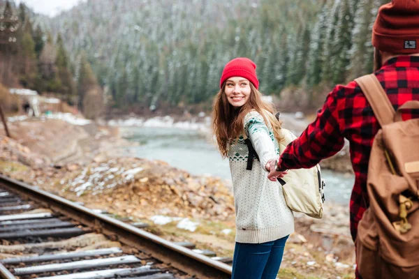 Щаслива молода пара тримає руки і йде по залізниці — стокове фото