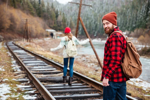 Man and woman walking on old railroad in mountains — Stock Photo, Image