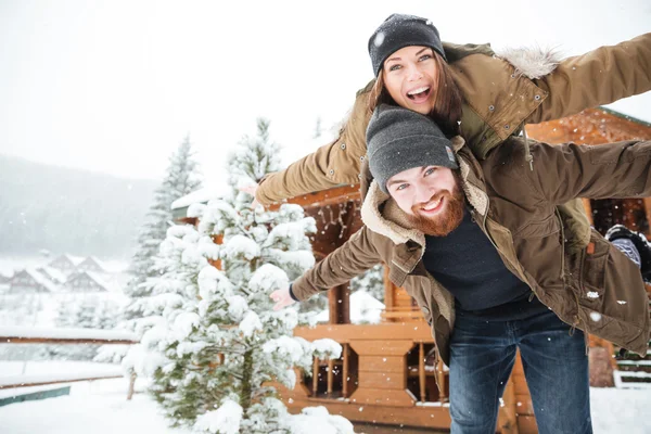 Homme heureux piggiback sa copine et rire en hiver — Photo
