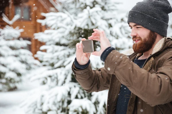 Λήψη φωτογραφιών με το κινητό τηλέφωνο το χειμώνα άνθρωπος — Φωτογραφία Αρχείου