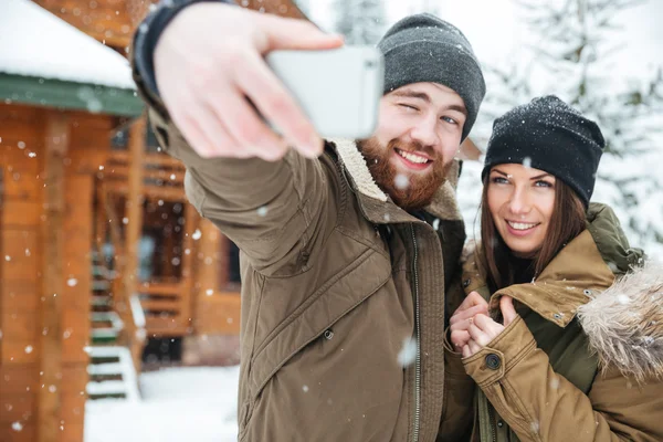 雪の降る天気で立っていると selfie のカップル — ストック写真