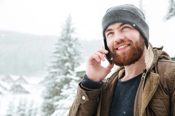 Schöner Mann, der im Winter draußen mit dem Handy telefoniert — Stockfoto