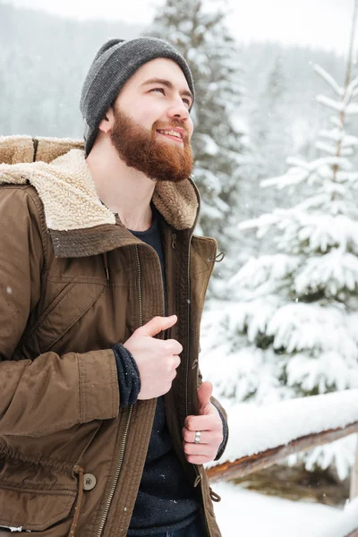 Улыбающийся человек стоит в горном зимнем лесу — стоковое фото