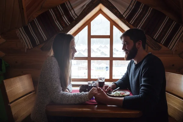 Το ζεύγος δείπνο συμμετέχουν κάθονται σε ξύλινο εξοχικό σπίτι χειμώνα — Φωτογραφία Αρχείου