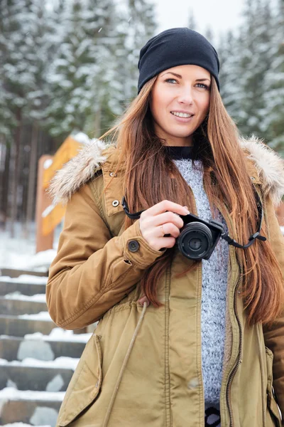 Hermosa mujer con cámara de fotos de pie en las escaleras en invierno —  Fotos de Stock